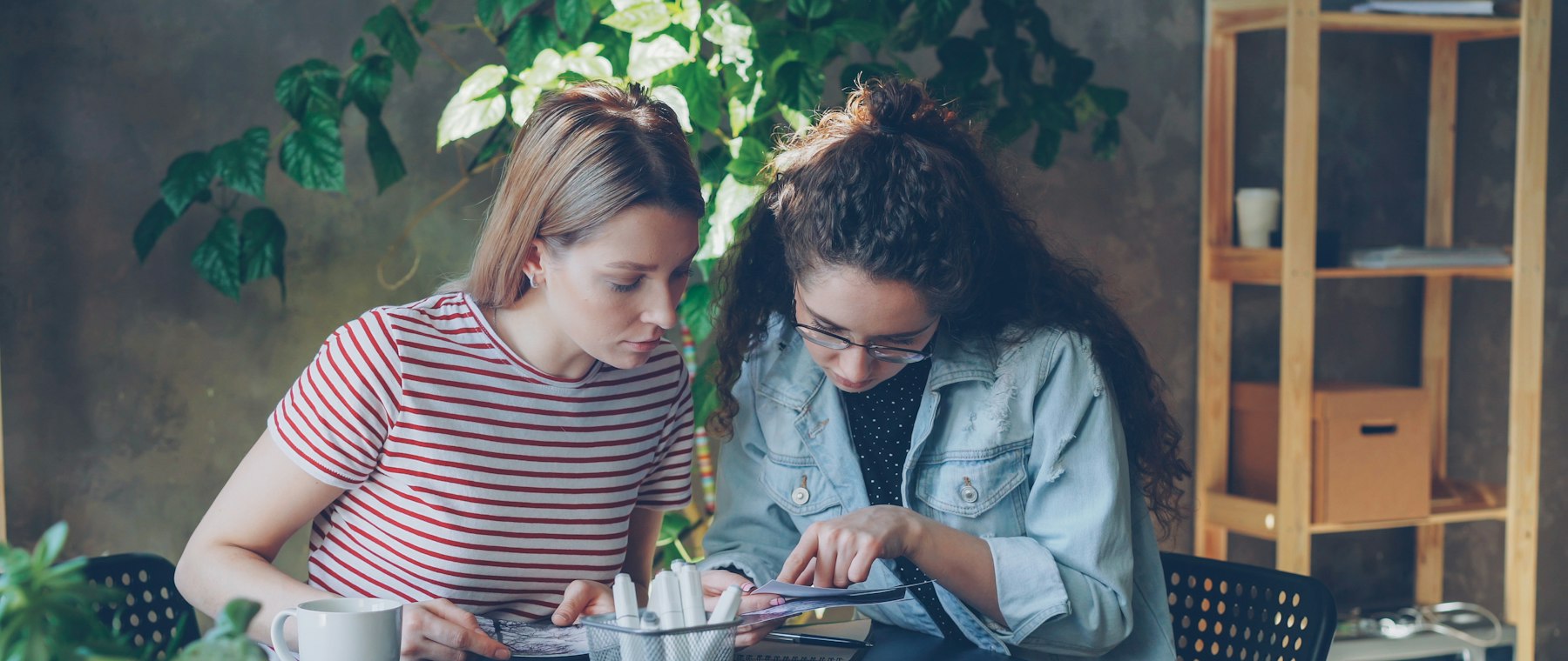Deux amies qui créent ensemble autour d’une table